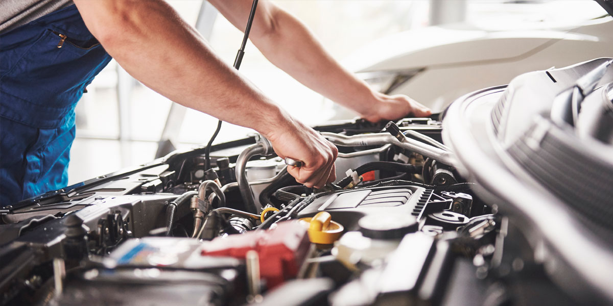 Man working on the engine of a car.