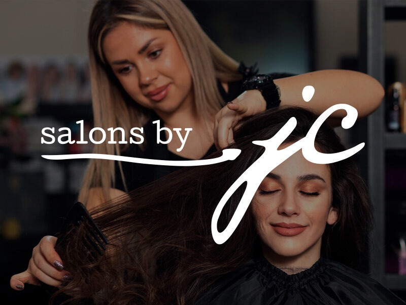 Salons by JC logo on top of an image of a woman having her hair styled.