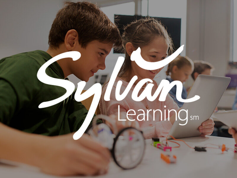 Sylvan Learning logo over an image of kids gathered around computers engaged in learning.