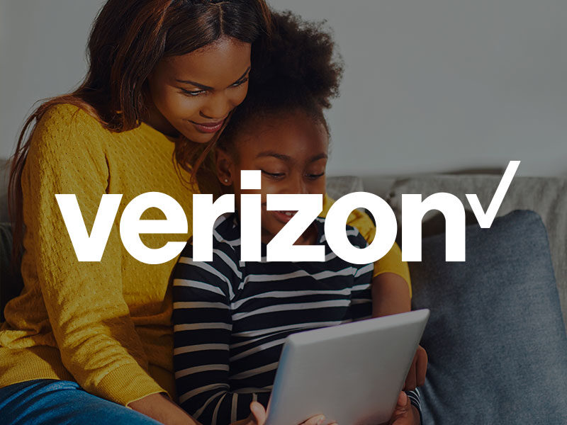 Verizon logo over an image of a black mother and child sitting on a couch watching a tablet.